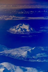 Aerial view of sea and snowcapped mountain against sky
