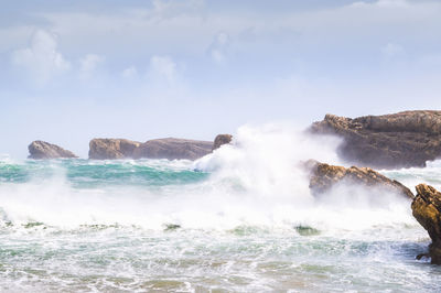 Scenic view of rocks in sea against sky