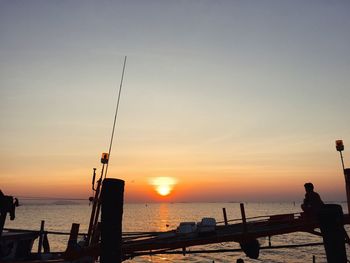 Silhouette people on beach against sky during sunset