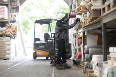 Young man wearing hard hat working in a warehouse