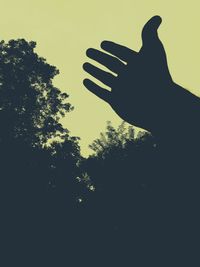 Low angle view of silhouette hand against clear sky