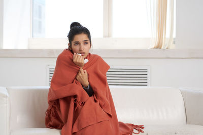 Portrait of woman sitting on sofa at home