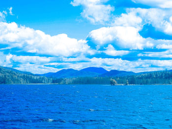 Scenic view of sea and mountains against sky