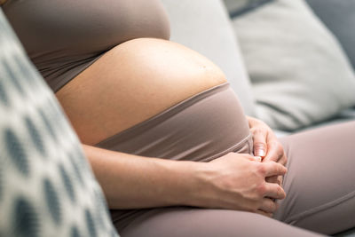 Midsection of woman doing yoga at home