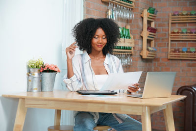 Young woman using laptop at table