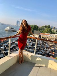 Full length of young woman standing on boat against sky