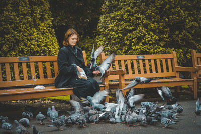 Portrait of man sitting on bench in park
