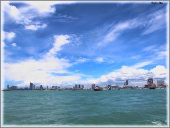 Boats in sea with buildings in background