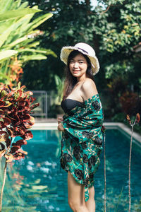 Portrait of smiling woman standing at poolside