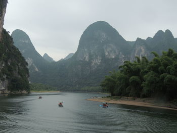 Scenic view of river and mountains against sky