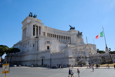 Low angle view of statues against blue sky