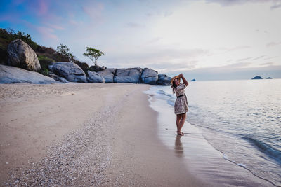 Full length of woman on beach against sky