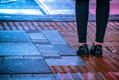 Low section of woman standing on tiled floor