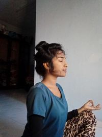 Side view of teenage boy looking away against wall at home