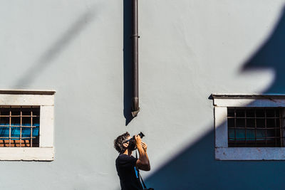 Man photographing against wall