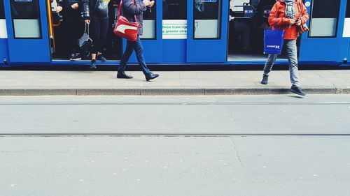 Low section of woman standing at railroad station