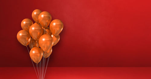 Close-up of heart shaped balloons against red background