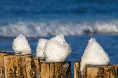 Close-up of wooden poles against blurred water