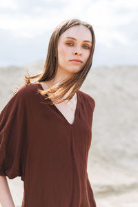 Portrait of beautiful young woman standing on beach