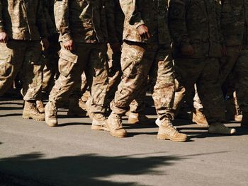 Low section of army soldiers walking on street