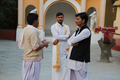 Men in traditional clothing standing on walkway