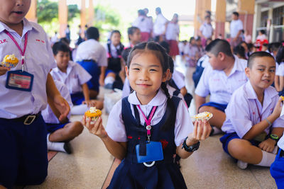 Portrait of a smiling girl with people in background