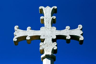 Low angle view of cross against blue sky