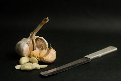 Close-up of garlic on table against black background