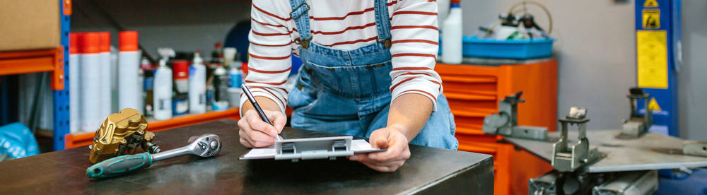 Woman checking stock products in workshop