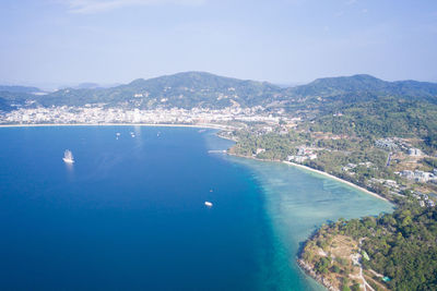 Aerial view of sea and cityscape against sky