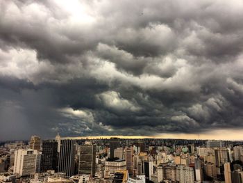 Aerial view of city against cloudy sky