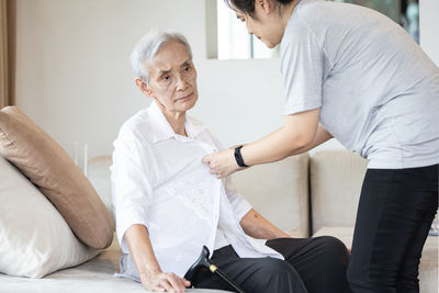Man sitting on table with people in background