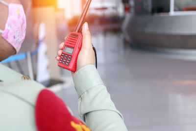 Midsection of woman holding mobile phone