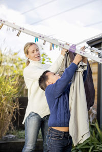 Mother and son drying laundry at yard