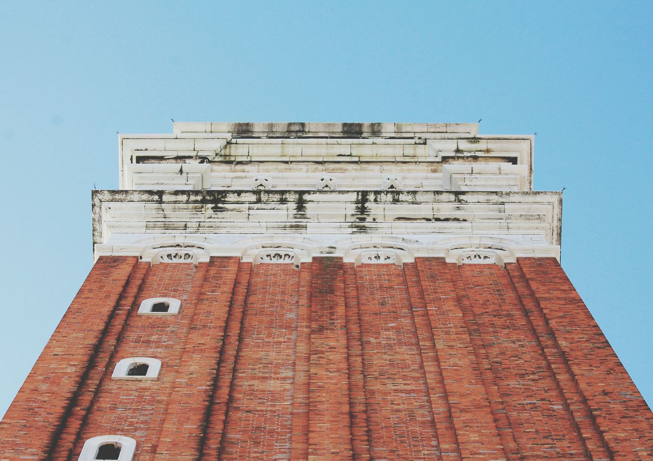 architecture, building exterior, built structure, low angle view, clear sky, building, brick wall, copy space, window, blue, day, wall - building feature, tower, outdoors, city, old, no people, exterior, residential building, residential structure