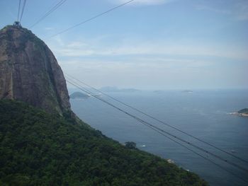 Overhead cable car over mountain against sky