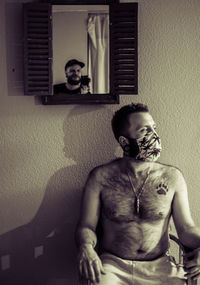 Portrait of young man sitting on sofa at home