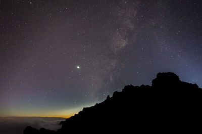 Scenic view of mountains against sky at night