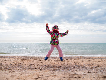 Little girl jumping on empty beach flying in the air lifestyle people scenic landscape active family