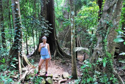 Portrait of mid adult woman standing amidst trees in forest