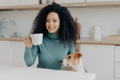 Smiling woman with dog at home