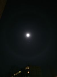 Low angle view of illuminated moon against sky at night