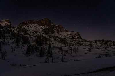 Scenic view of snowcapped mountains against sky at night