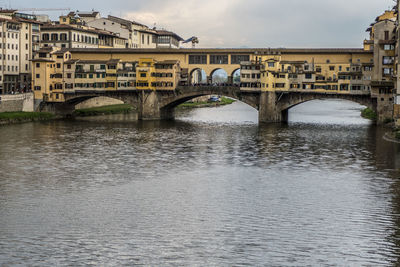 Bridge over river in city against sky