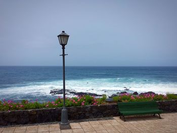 Street light by sea against clear sky