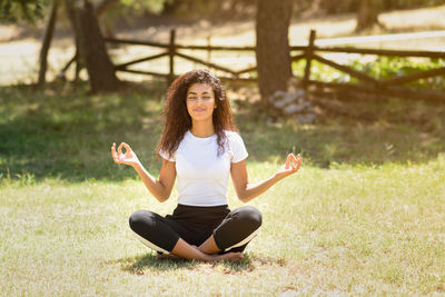 Full length of young woman meditating at park