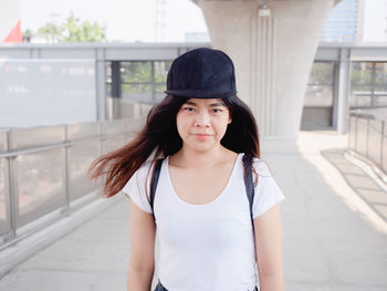 Portrait of young woman standing in city