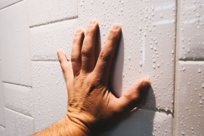 Close-up of hand on wet wall
