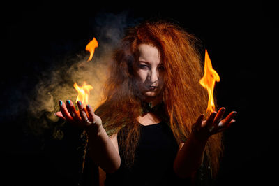 Portrait of woman against black background