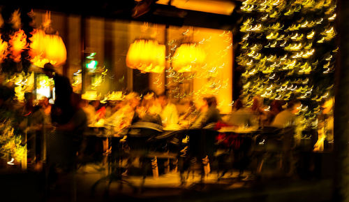 Defocused image of people by illuminated street at night